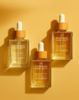 Three bottles of Rosemary Hair Oil Co. on a yellow background