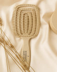 Beige paddle hairbrush with 'Rosemary Hair Oil' branding on a beige fabric background. Beige hairbrush with 'Rosemary Hair Oil Co.' branding on a beige background, detangle brush, tangle teaser, flexi brush