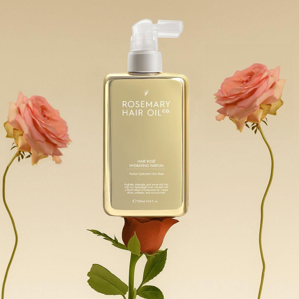 Hair Rosé Hydrating Parfum Mist. Rosemary hair oil bottle with pump and pink roses on a beige background. “Luxury hair perfume mist designed to hydrate dry hair and add a soft floral scent. 