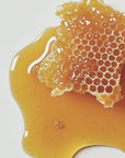 Honeycomb with honey on a white background. SLS-free pro-keratin growth shampoo with honey to gently cleanse and strengthen hair